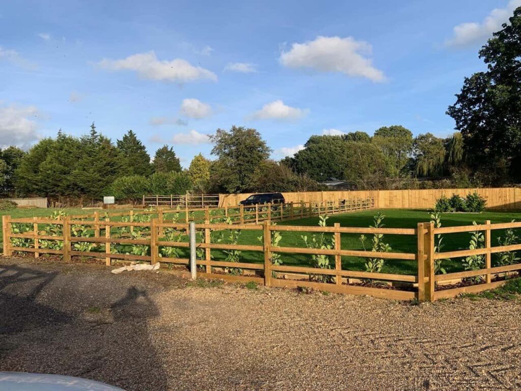 This is a photo of post and rail fencing with a gravel board installed at the base to create a flower bed, and at the rear is feather edge fencing along the edge of the garden. All works carried out by Fast Fix Fencing Mildenhall